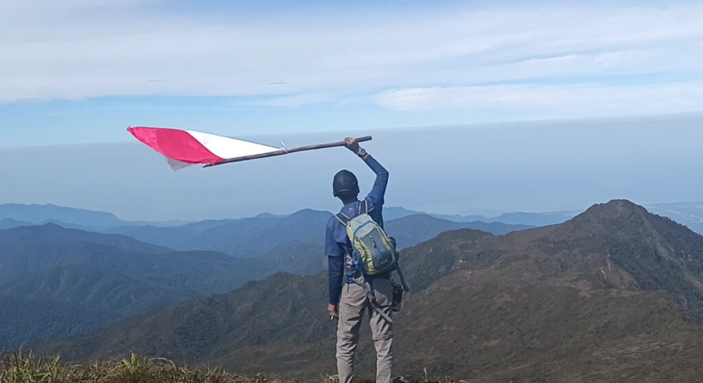 Pendaki mengibarkan bendera merah putih di Puncak Loser, Gunung Leuser, sebagai simbol ketahanan dan refleksi diri